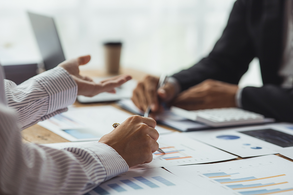 Businessmen are reviewing documents for analysis and marketing plans
